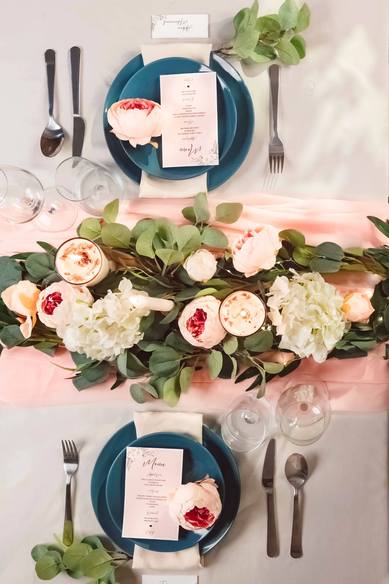Elegant table setting with teal plates and blush florals